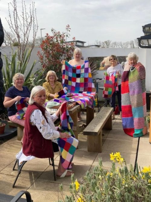 Club members making blankets from the knitting squares from the knit and natter challenge