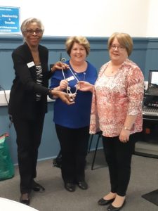 Pres Myrtle transferring the chain of office to our new co-presidents, Christine and Fiona