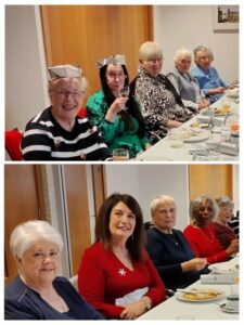 Women sitting at tables smiling. 