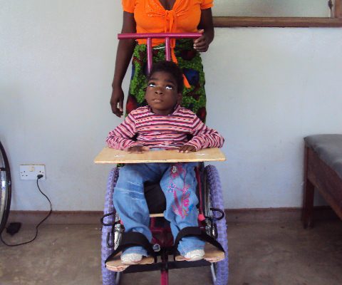 Little girl with cerebral palsy in a wheelchair made in Blantyre Malawi