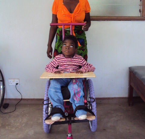 Little girl with cerebral palsy in a wheelchair made in Blantyre Malawi