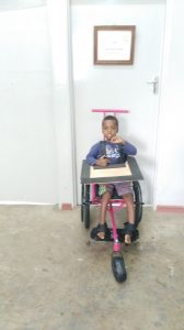 Malawian boy in a wheelchair with tray