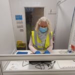 woman in mask behind screen