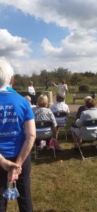 Women seated watching unveiling of Dynamic S statue at National Arboretum