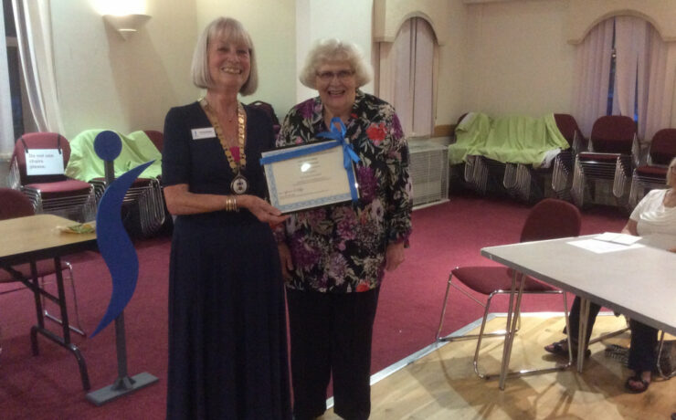 Two women with standing with framed certificate of long service