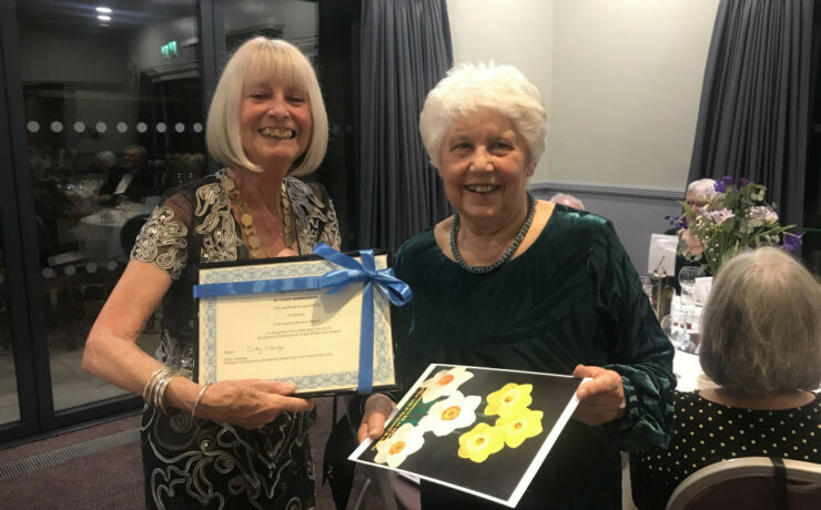 two women, one holding a certificate