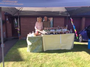 Two people sell a stall to sell jams and other food stuff