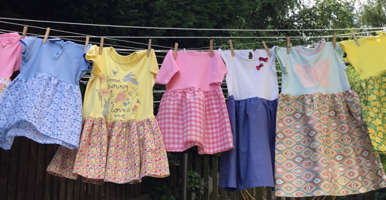 A washing line full of T Shirt Dresses made by SI Lichfield members for girls in Kori and Manila