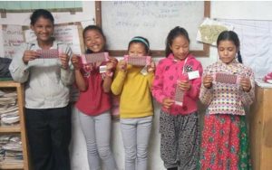 Nepalese girls show off their new sanitary packs