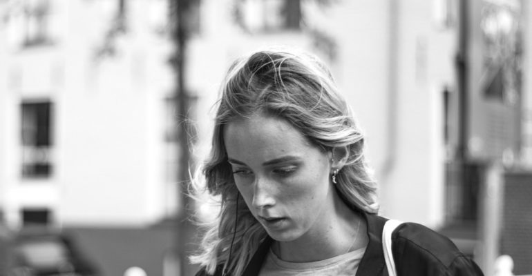 Witness Protection Photo of a woman looking downwards against a city background