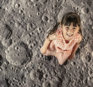 Photo of little girl apparently standing on the surface of the moon
