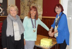 Immediate past President Stephanie with Helen and Janet, cutting their cake.