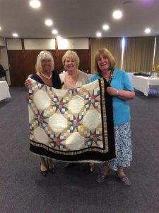 Eirwe being presented with the quilt by, Dot and Jean. 