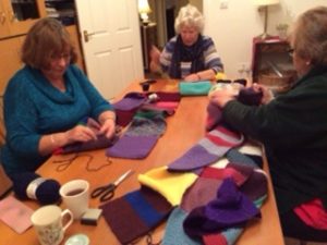 Photo of people sewing the blanket together