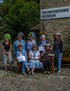 Members show off their Hats made from recycled materials