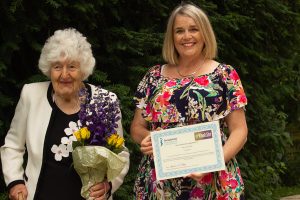 President Eleanor presents Mary with her certificate and flowers 