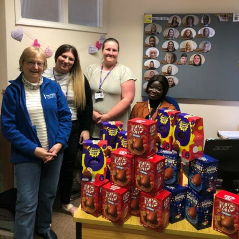 Swindon Soroptimist Jackie Webb with Carrie, Kerry and Ella from the Nelson Trust Women’s Centre all stand behind a stack of boxed Easter eggs